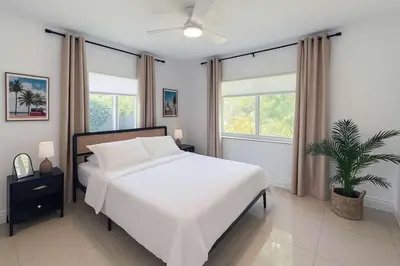a bedroom with a white bed and a potted plant at Stylish 2BR Getaway - Prime Miami Location in Miami