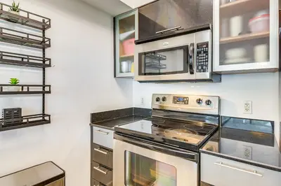 a kitchen with a stove and a microwave at Bayside Miami High-Rise Condo By Waterfront Park! in Miami