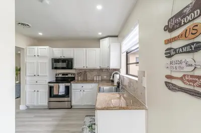 a kitchen with white cabinets and a sink at Golden Welcome in Hollywood