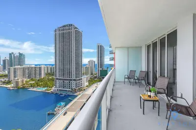 a balcony with chairs and a view of the water at Infinite Views - Private Balcony -Poolside Bliss Near the Beach in Hallandale Beach