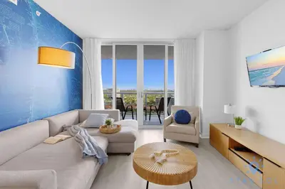 a living room with a couch and a table at Balcony with Infinite Views - Poolside Comfort in Hallandale Beach