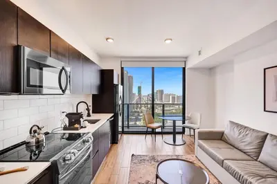a kitchen and living room with a couch and a table at Lux Miami Studio City Bay Views in Miami