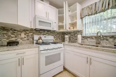 a kitchen with white cabinets and a stove top oven at Less Than 3 Mi to Hard Rock Stadium Miami Home with Sunroom in Miami