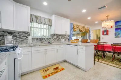 a kitchen with white cabinets and a dining room at Less Than 3 Mi to Hard Rock Stadium Miami Home with Sunroom in Miami
