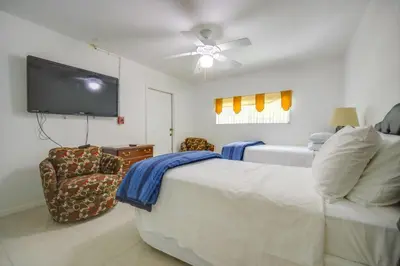 a bedroom with a bed and a flat screen tv at Less Than 3 Mi to Hard Rock Stadium Miami Home with Sunroom in Miami