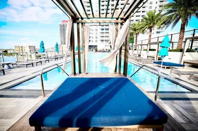 a blue bench sitting next to a swimming pool at 2 BDR Stunning Ocean View in Hyde Beach House in Hollywood