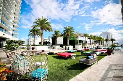 a patio with chairs and tables and palm trees at 2 BDR Stunning Ocean View in Hyde Beach House in Hollywood