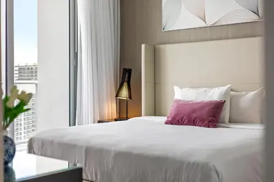 a bedroom with a large white bed with a purple pillow at 2 BDR Penthouse Ocean Front View Hyde Beach House in Hollywood