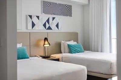 two beds in a hotel room with blue pillows at 2 BDR Penthouse Ocean Front View Hyde Beach House in Hollywood