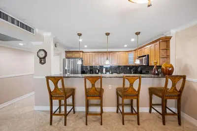 a kitchen with three bar stools and a counter at Entire Condominium in Sunny Isles in Sunny Isles Beach
