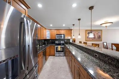 a kitchen with wooden cabinets and a stainless steel refrigerator at Entire Condominium in Sunny Isles in Sunny Isles Beach