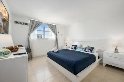 a white bedroom with a bed and a desk at Bright Stylish 2BR Condo Stunning View Of Ocean in Sunny Isles Beach