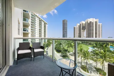 a balcony with two chairs and a view of the city at Bright Stylish 2BR Condo Stunning View Of Ocean in Sunny Isles Beach