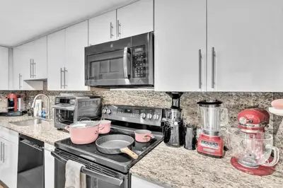 a kitchen with white cabinets and a stove top oven at Coconut Grove Haven Family in Miami
