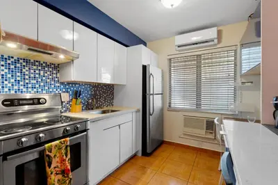 a kitchen with white cabinets and a stainless steel refrigerator at 1BR Studio Parking, Pet Friendly and BBQ Area in Hollywood