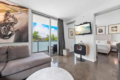 a living room with a couch and a tv at Large Beach Suite Rooftop Pool by Convention Center in Miami Beach