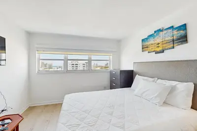 a white bedroom with a bed and two windows at Miami Lux Haven in Miami Beach