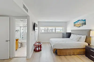 a bedroom with a large bed and a bathroom at Miami Lux Haven in Miami Beach