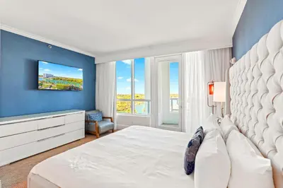 a bedroom with a white bed and a blue wall at Luxury Condo at Trésor Miami Beach in Miami Beach