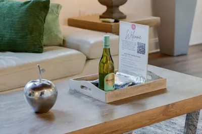 a bottle of wine and an apple on a coffee table at Hidden Bungalow- Peaceful retreat BBQ and hot tub in Miami