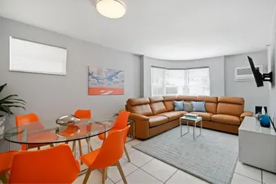 a living room with a couch and a table and chairs at South Beach Luxury, 2 Bedroom, Across from Beach in Miami Beach