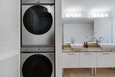a kitchen with a microwave and a washer and dryer at Brickell River Views- modern amenities in the city in Miami