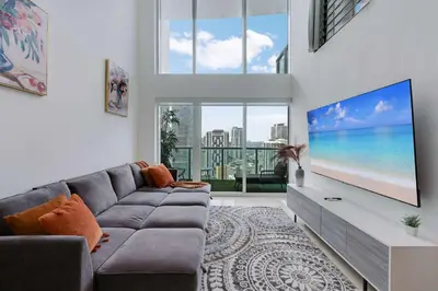 a living room with a couch and a flat screen tv at Brickell River Views- modern amenities in the city in Miami