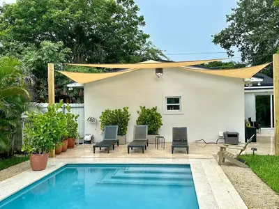 a house with a swimming pool with a yellow umbrella at Vibrant 4bd 2ba Miami Home w POOL in Miami