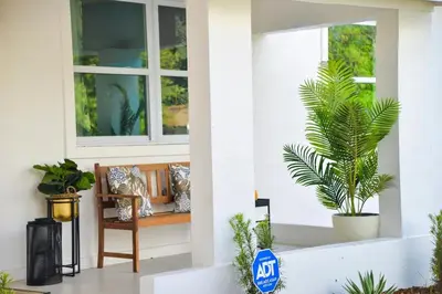 a porch with a bench and a palm tree at Vibrant 4bd 2ba Miami Home w POOL in Miami