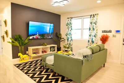 a living room with a green couch and a flat screen tv at Vibrant 4bd 2ba Miami Home w POOL in Miami