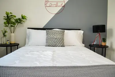 a bedroom with a bed with white sheets and pillows at Vibrant 4bd 2ba Miami Home w POOL in Miami
