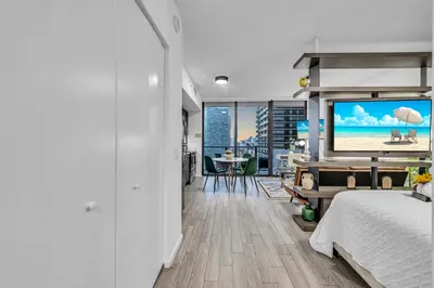 a bedroom with a bed and a flat screen tv at Modern Studio City Views in Miami