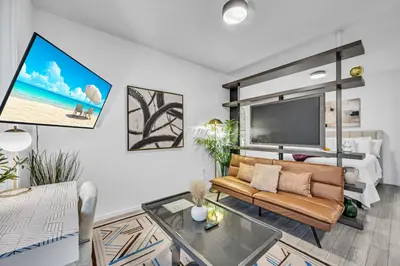 a living room with a couch and a tv at Modern Studio City Views in Miami
