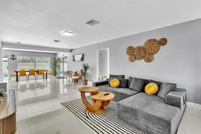 a living room with a couch and a table at 4BR Home Heated Pool And BBQ short drive Beach! in Hollywood