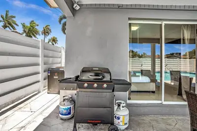 a grill sitting on a patio next to a house at 4BR Home Heated Pool And BBQ short drive Beach! in Hollywood