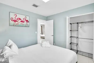 a white bedroom with pink flamingos on the wall at 4BR Home Heated Pool And BBQ short drive Beach! in Hollywood