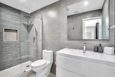 a bathroom with a toilet and a sink and a shower at 4BR Home Heated Pool And BBQ short drive Beach! in Hollywood