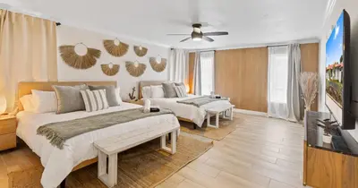 a bedroom with two beds and a flat screen tv at Boho Style 5 BR 2,5 BT Heated Pool Fit 14 in Miami