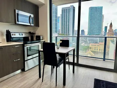 a kitchen with a table with a laptop on it at Heart of Downtown Miami in Miami