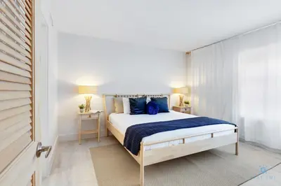 a bedroom with a large bed with blue pillows at Spacious Apt 2 Blocks to Beach and Collins Park in Miami Beach