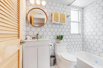 a bathroom with a toilet and a sink and a mirror at Spacious Apt 2 Blocks to Beach and Collins Park in Miami Beach