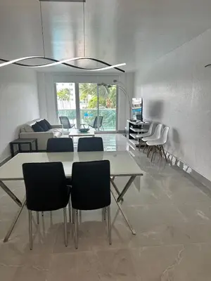 a living room with a dining table and chairs at Beatiful apartment 2nd Floor - SRT 3143 in Sunny Isles Beach