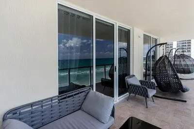 a living room with a couch and chairs on a balcony at Pierfront Escape in Sunny Isles Beach