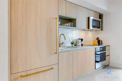 a kitchen with wooden cabinets with a sink and a microwave at Condo Downtown in Miami