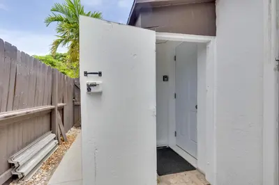 an open door to a house with a fence at Fort Lauderdale Studio Near Beaches and Downtown in Fort Lauderdale