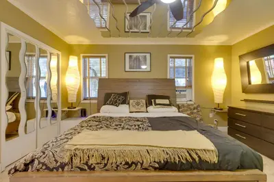 a bedroom with a large bed and yellow walls at Fort Lauderdale Studio Near Beaches and Downtown in Fort Lauderdale