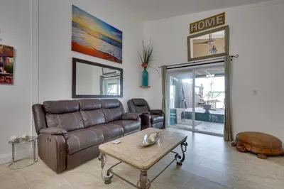 a living room with a leather couch and a coffee table at Lakefront Getaway with Dock Near Las Olas Beach in Fort Lauderdale