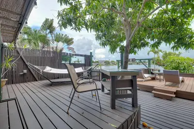 a deck with a hammock and a table and chairs at Lakefront Getaway with Dock Near Las Olas Beach in Fort Lauderdale