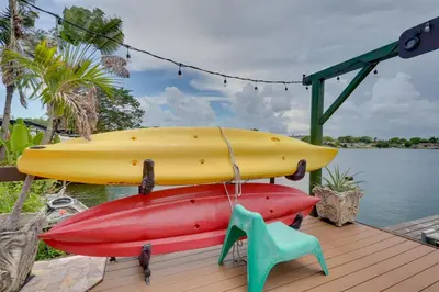 three surfboards sitting on a deck next to the water at Lakefront Getaway with Dock Near Las Olas Beach in Fort Lauderdale