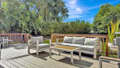 a patio with a couch and chairs on a deck at Brickell, Remote-Ready Oasis in Miami